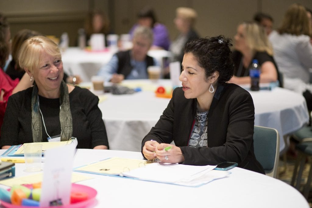 Past Trainers Institute participants discussing a topic during a small group activity.