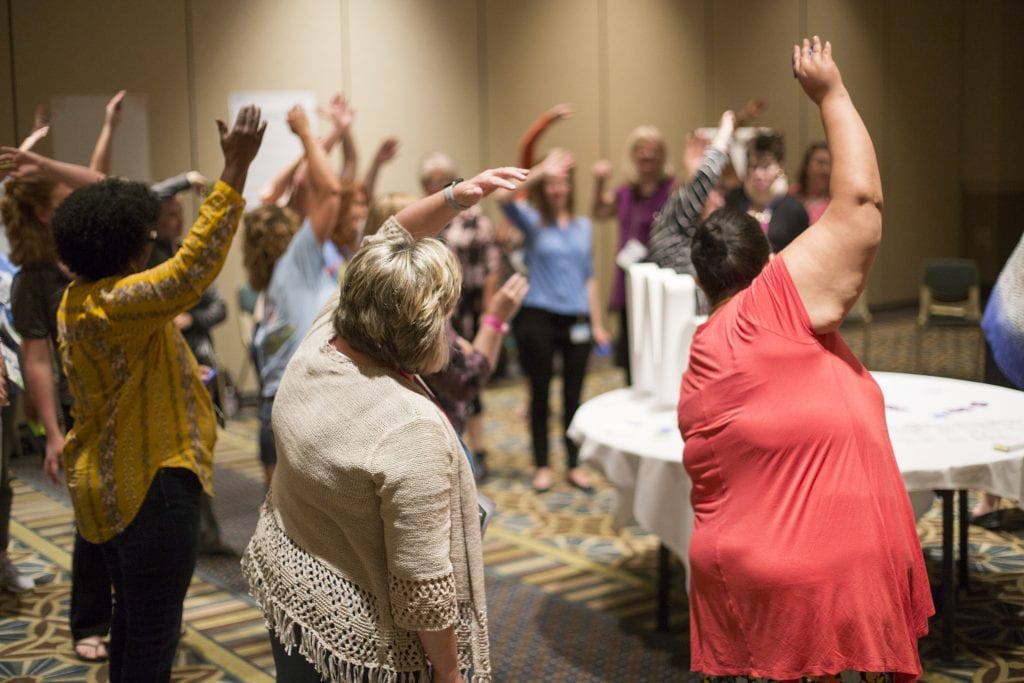 Trainers Institute participants engaged in large group activity during a session.